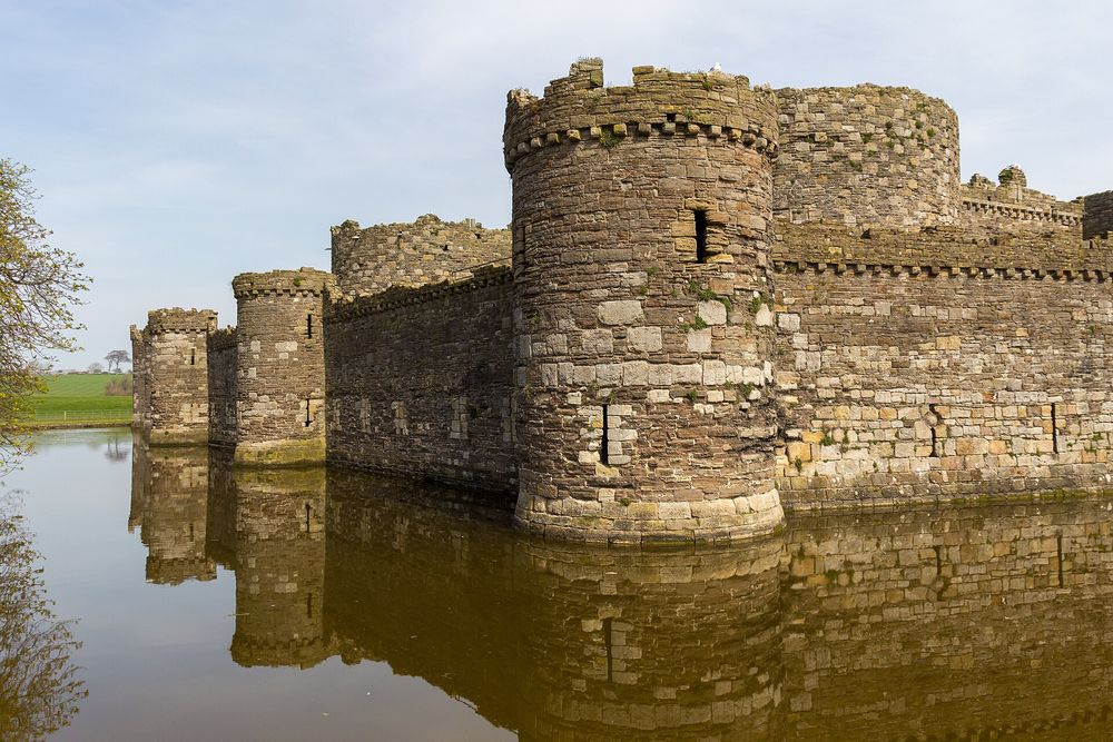 The concentric stone walls, water moat, and defensive towers of Beaumaris Castle in Anglesey, Wales