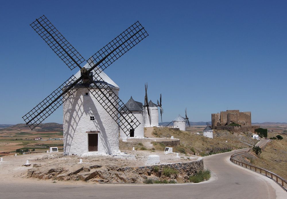 Vintage windmill against an open landscape under a dramatic sky in Castile-La Mancha
